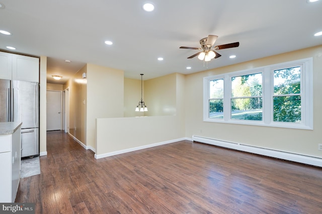 empty room featuring a baseboard radiator, dark wood-type flooring, and ceiling fan with notable chandelier