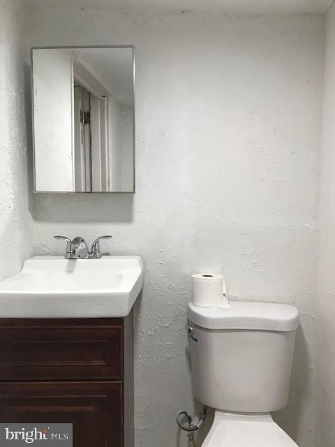 half bath featuring toilet and vanity