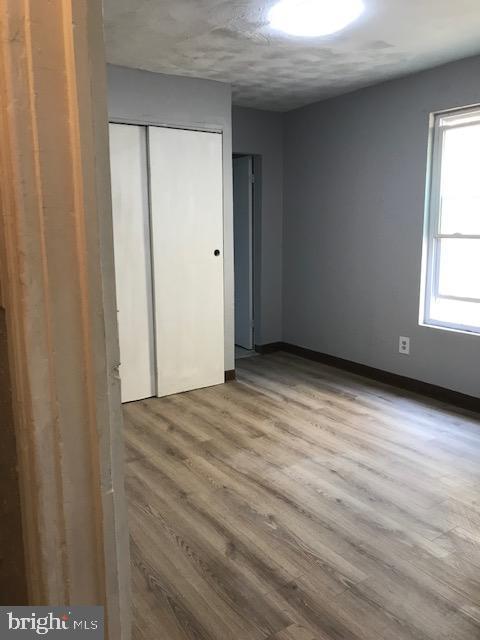 interior space with baseboards, wood finished floors, and a closet