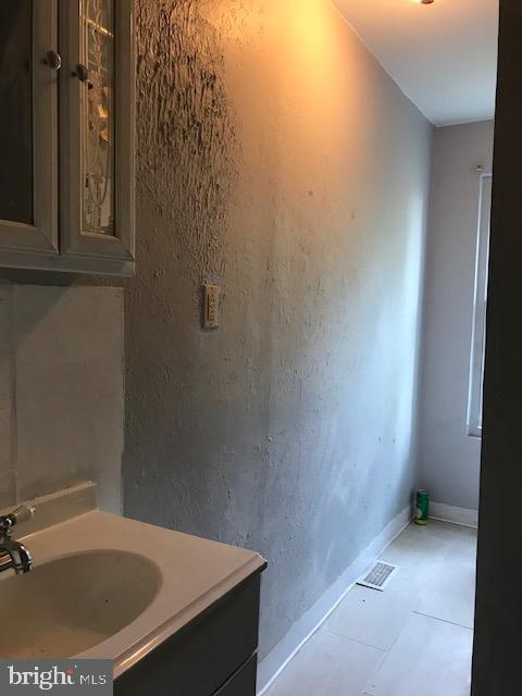 bathroom with baseboards, vanity, and visible vents