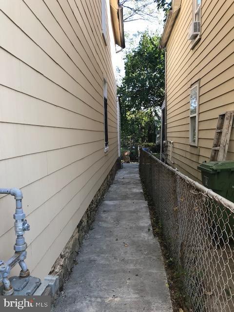 view of side of home with cooling unit and fence
