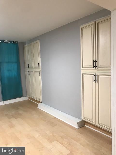 empty room with light wood finished floors and baseboards