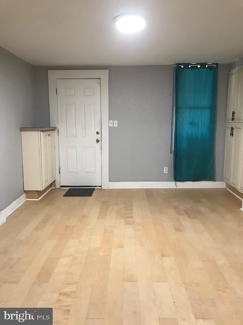 entryway with baseboards and light wood-style flooring