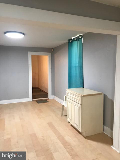 hallway with baseboards and light wood-style flooring