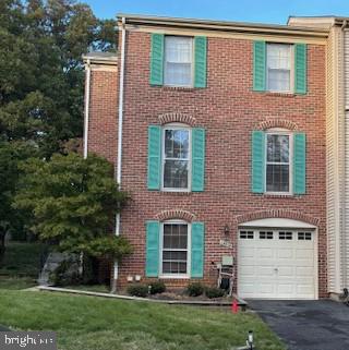 townhome / multi-family property featuring a front yard and a garage