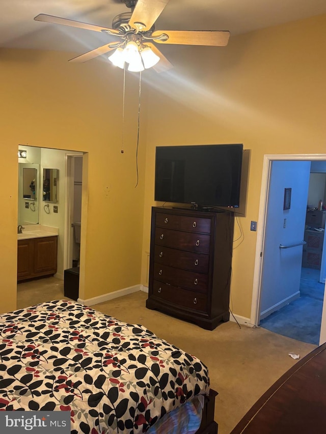 bedroom with ensuite bathroom, a towering ceiling, ceiling fan, and light carpet