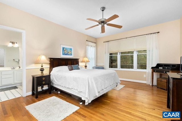 bedroom with ceiling fan, light hardwood / wood-style floors, and ensuite bath