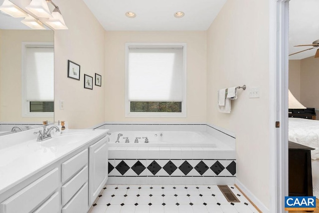 bathroom with vanity, tiled bath, and ceiling fan