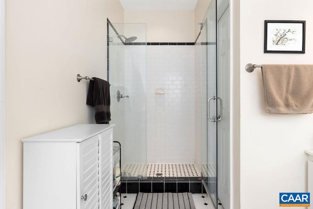 bathroom with a shower with door and tile patterned flooring