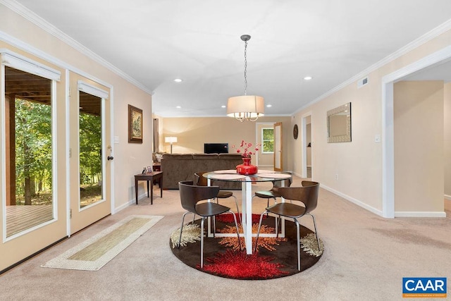 carpeted dining area with ornamental molding and an inviting chandelier