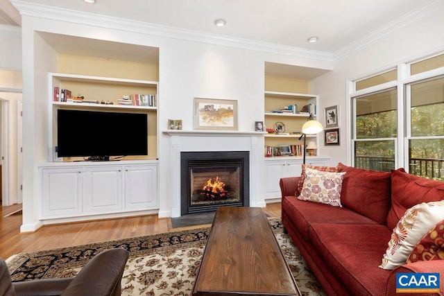 living room with crown molding, wood-type flooring, and built in shelves