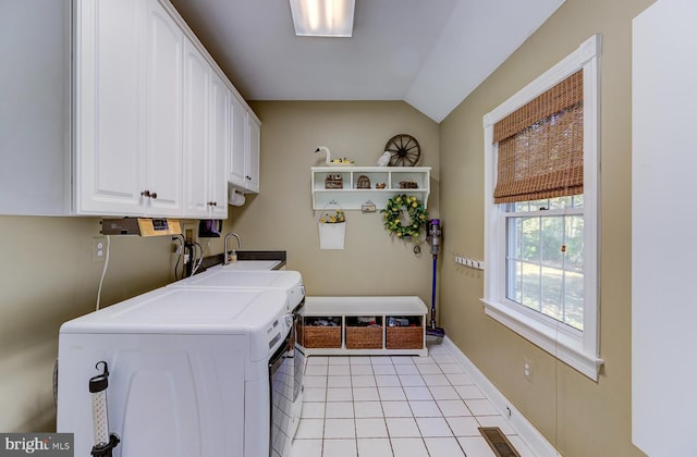 clothes washing area with cabinets, sink, washing machine and dryer, and light tile patterned floors