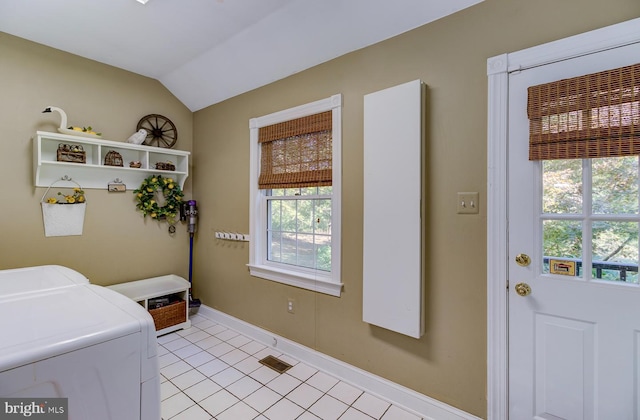 clothes washing area featuring washing machine and dryer, light tile patterned flooring, and plenty of natural light