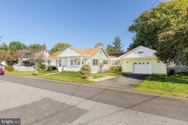 view of front of home featuring a front yard, a garage, and covered porch