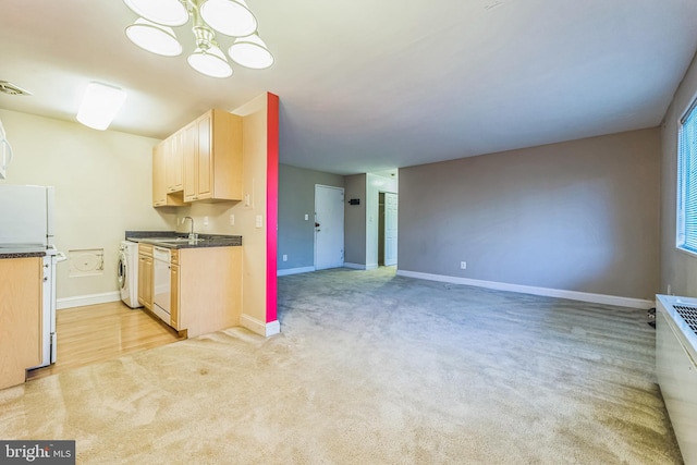 kitchen with light brown cabinets, sink, washer / clothes dryer, white appliances, and light carpet