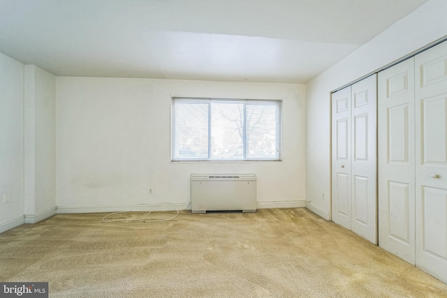 unfurnished bedroom featuring light carpet and a closet