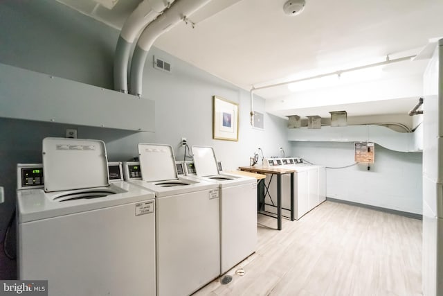 clothes washing area featuring light wood-type flooring and independent washer and dryer