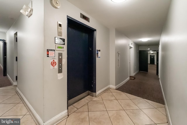 hall with elevator and light tile patterned flooring