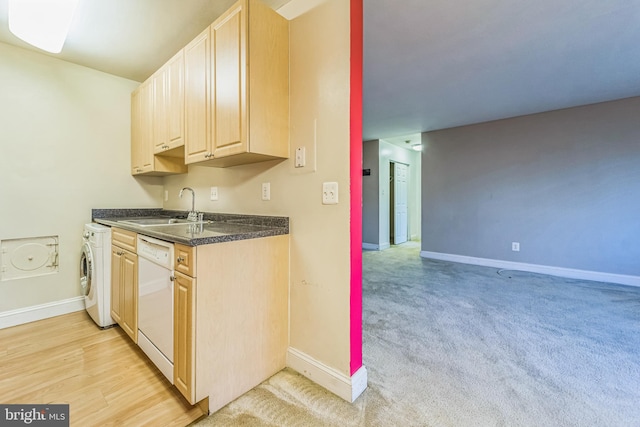 kitchen featuring dishwasher, washer / dryer, sink, and light brown cabinetry