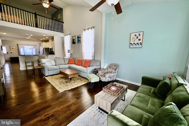 living room featuring dark wood-type flooring, high vaulted ceiling, and ceiling fan