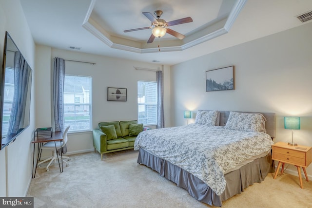 carpeted bedroom featuring ceiling fan, ornamental molding, and a tray ceiling