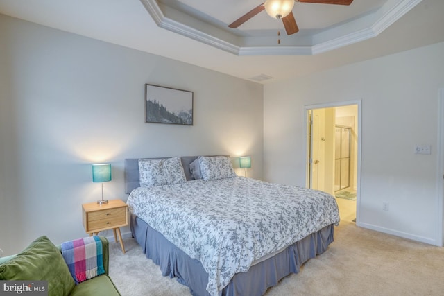 carpeted bedroom featuring ceiling fan, a raised ceiling, crown molding, and ensuite bath