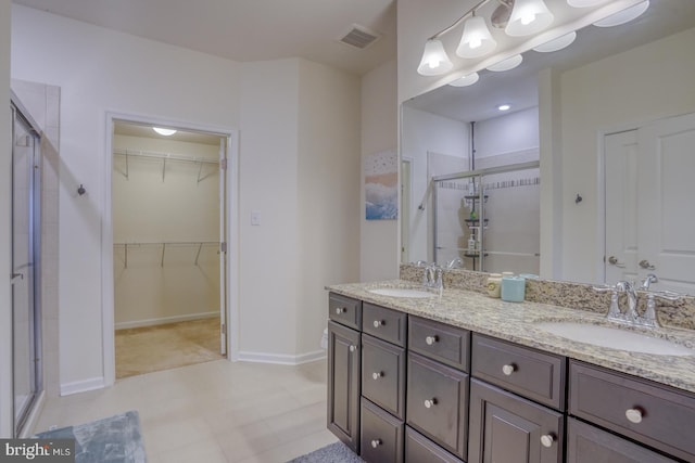 bathroom with a shower with door and vanity