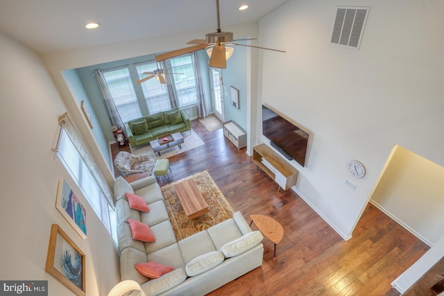 living room featuring ceiling fan, high vaulted ceiling, wood-type flooring, and a wealth of natural light