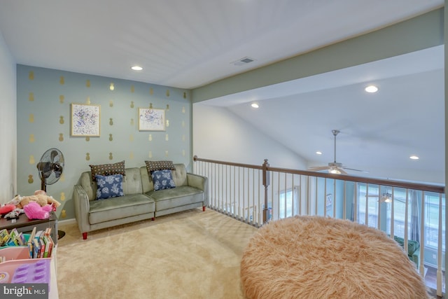 living area with ceiling fan, light carpet, and vaulted ceiling