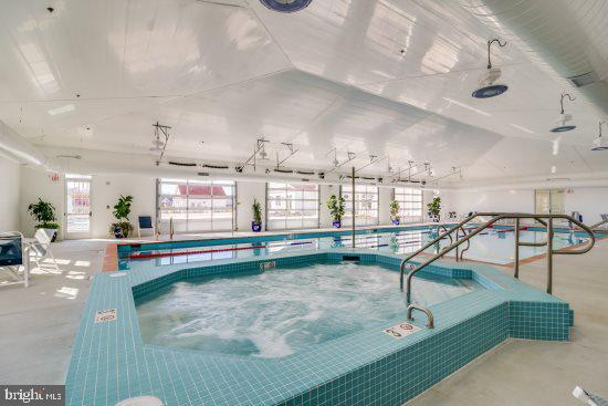 view of swimming pool with an indoor hot tub