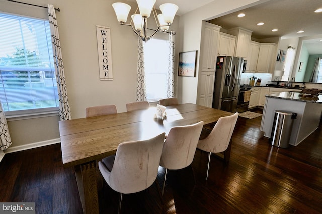 dining room featuring sink, an inviting chandelier, and dark hardwood / wood-style flooring