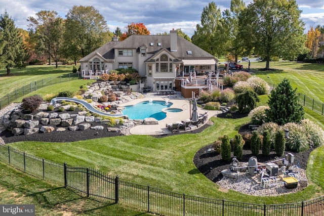 back of property featuring a patio, an outdoor fire pit, a lawn, and a swimming pool side deck