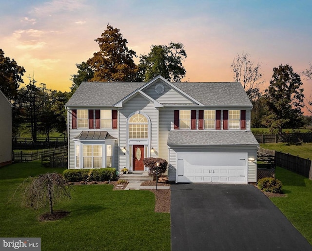 view of front of home with a garage and a yard