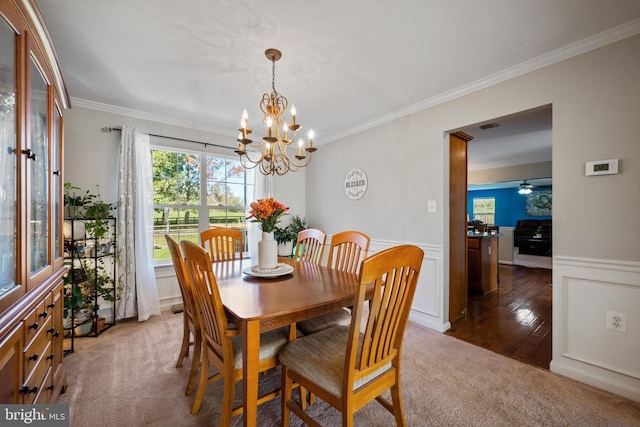 dining room with crown molding, ceiling fan with notable chandelier, and dark hardwood / wood-style flooring