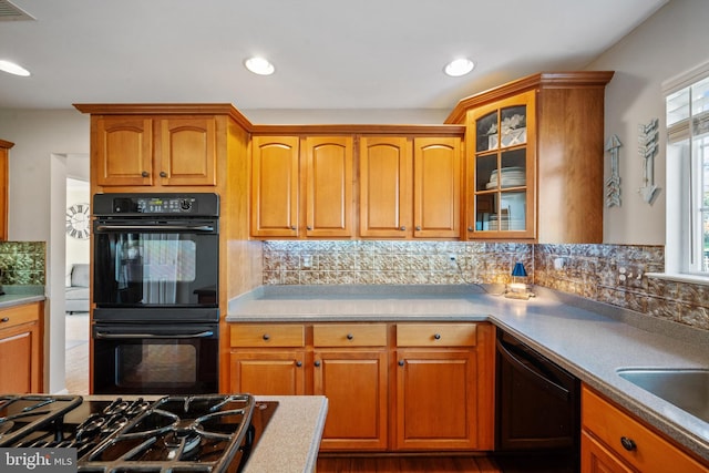 kitchen featuring backsplash, sink, and black appliances