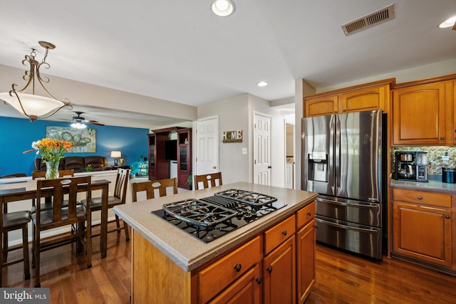 kitchen featuring pendant lighting, ceiling fan, a center island, stainless steel refrigerator with ice dispenser, and black gas stovetop