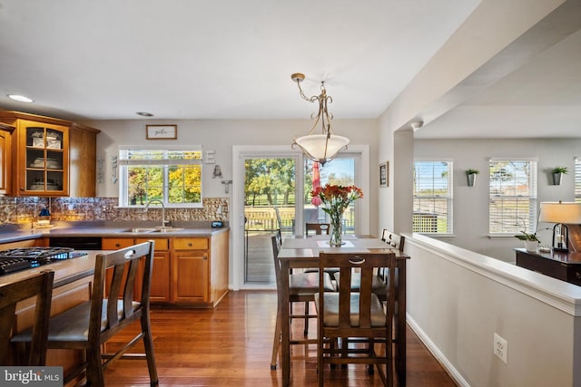 kitchen featuring dark hardwood / wood-style flooring, sink, decorative light fixtures, and a wealth of natural light