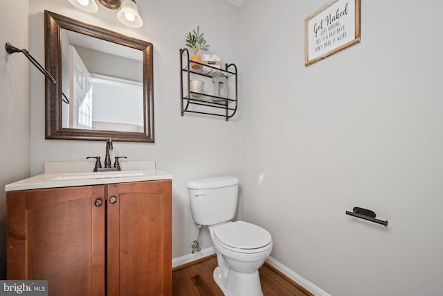 bathroom with vanity, toilet, and hardwood / wood-style floors