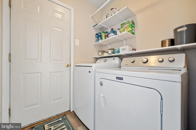 laundry room with light hardwood / wood-style floors and washer and dryer