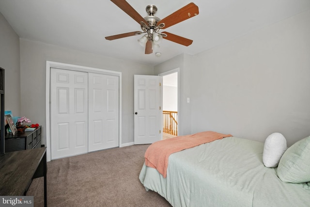 bedroom featuring light colored carpet, ceiling fan, and a closet