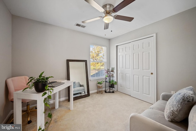 living area with light carpet and ceiling fan