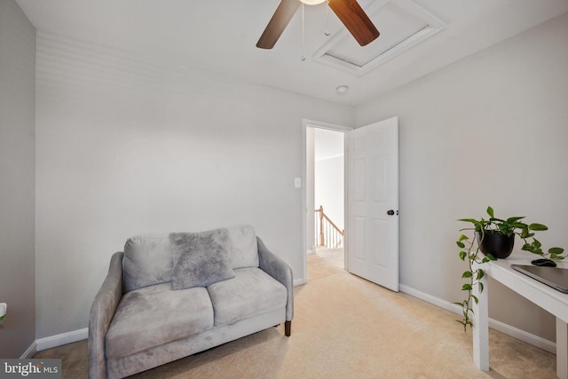 living area featuring light carpet and ceiling fan