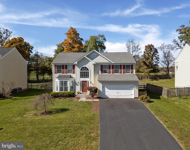 view of front of house featuring a garage, central AC, and a front lawn