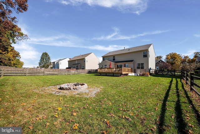 view of yard with a wooden deck and an outdoor fire pit