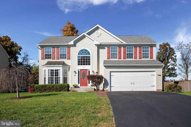 colonial home featuring a garage and a front yard