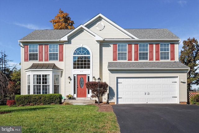 view of front of property with a garage and a front lawn