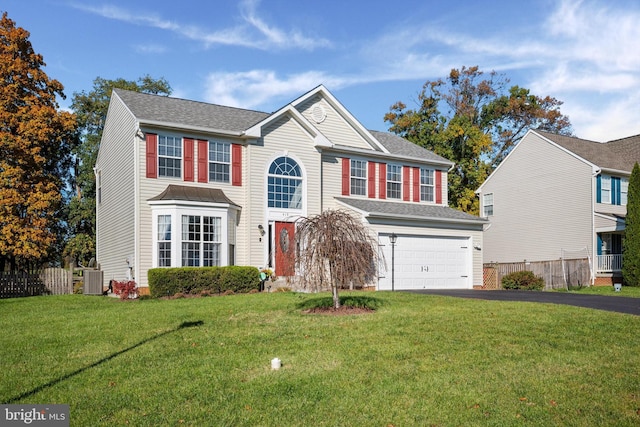 view of front facade featuring a garage, central AC, and a front lawn