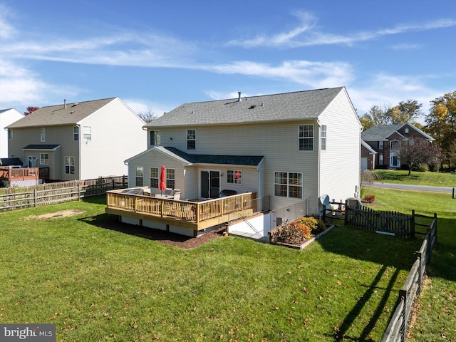 rear view of property featuring a lawn and a deck