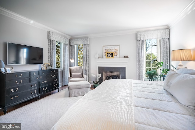 bedroom with ornamental molding, a tiled fireplace, and multiple windows