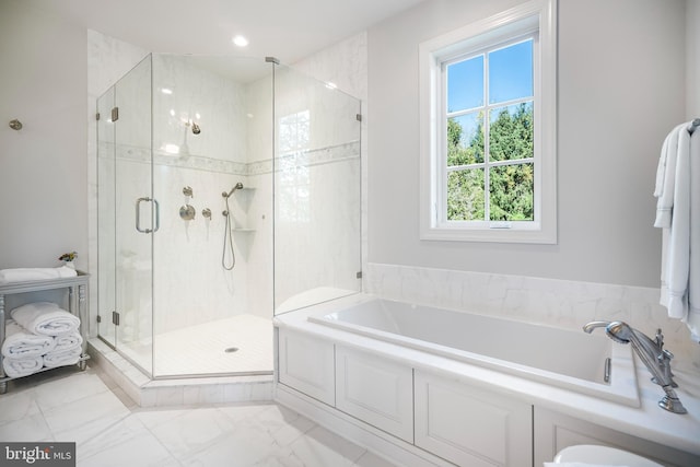 bathroom featuring shower with separate bathtub